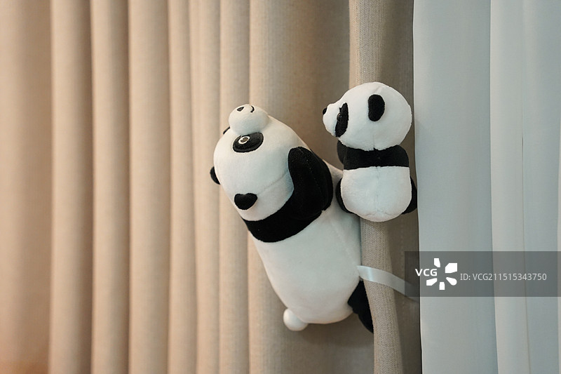 挂在窗帘的熊猫母子毛绒玩具特写镜头图片素材
