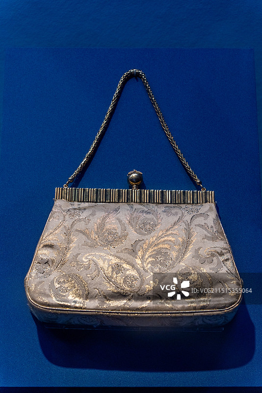 蓝色背景下古董金丝暗纹手提袋特写镜头图片素材