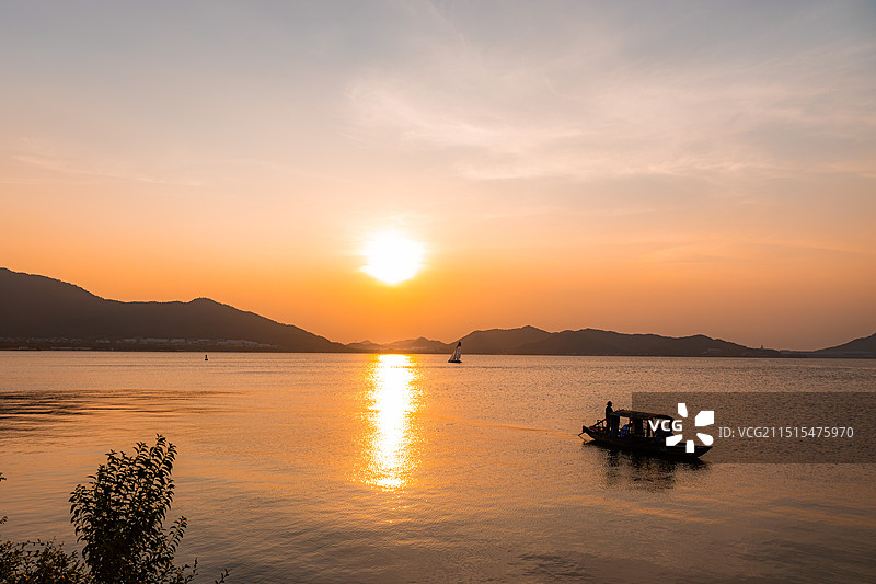 夕阳下，宁波东钱湖上的落日和船图片素材
