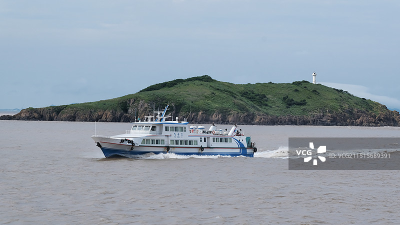海上航行的轮船和绿色孤岛图片素材
