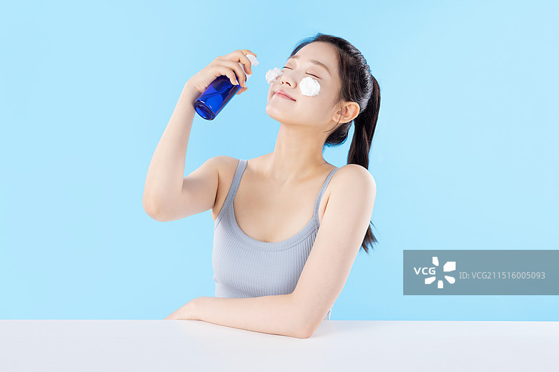 摆姿势展示化妆品的女青年图片素材