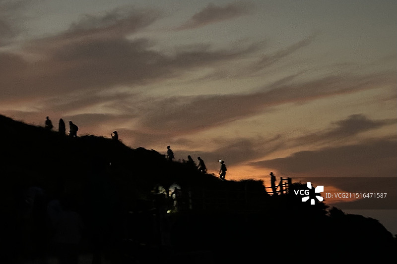 舟山枸杞嵊山岛，东崖绝壁，日出时的朝霞，灯塔，峭壁和看日出的人剪影图片素材