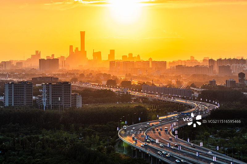 黄昏时刻，落日晚霞映照北京CBD城市天际线与蜿蜒的高架快速路图片素材