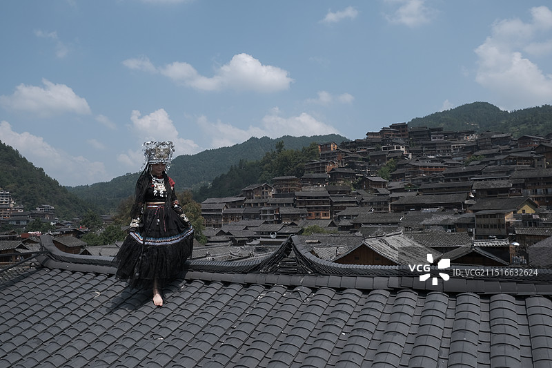 从屋顶走下来的苗族少女-千户苗寨人像摄影图片素材