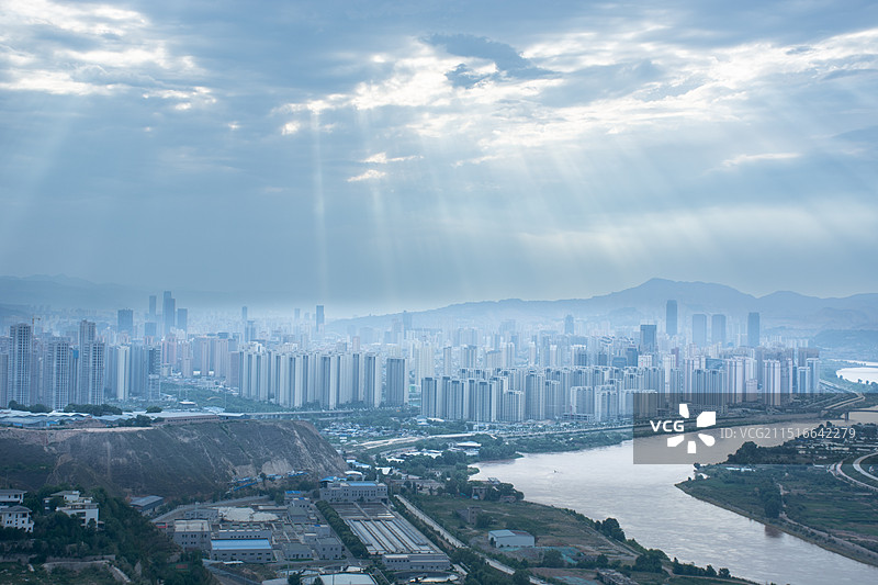 甘肃兰州黄河穿过城市中心，天空中出现丁达尔效应光束图片素材