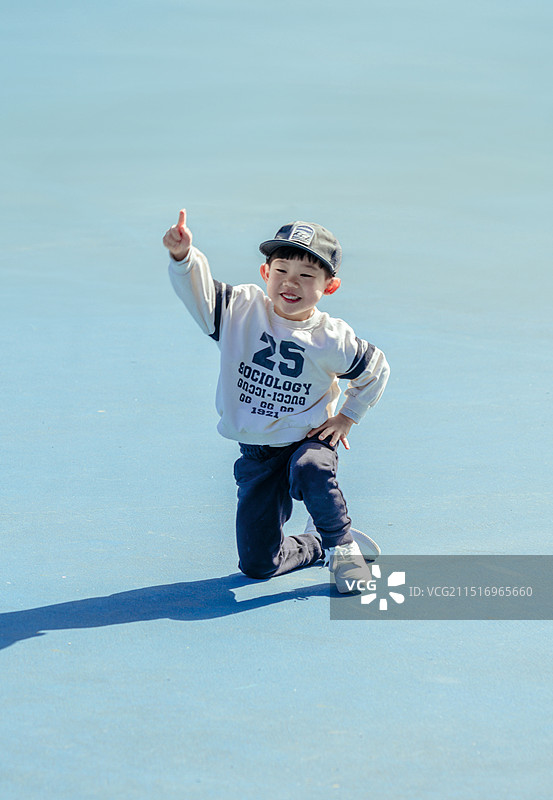 蓝色场地上的可爱男孩图片素材