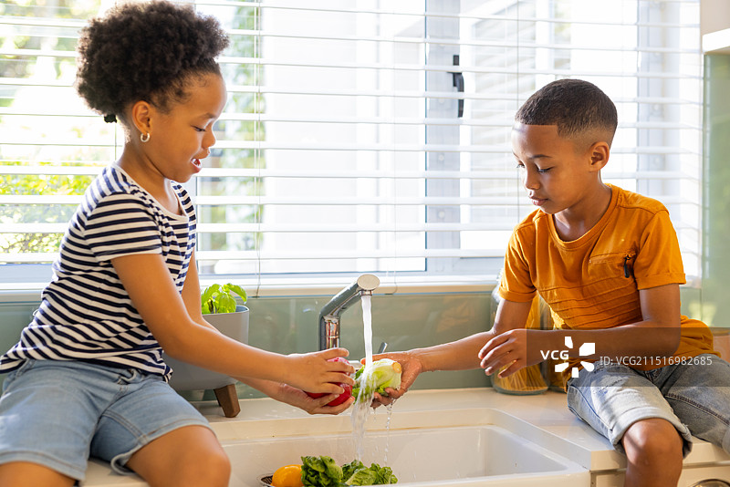 小兄妹在厨房一起洗菜准备健康餐图片素材