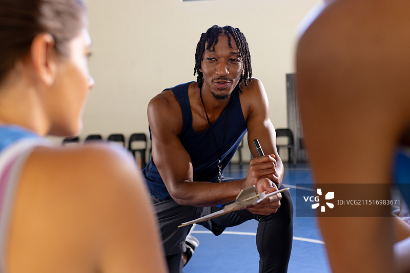 男教练在训练期间与女篮运动员讨论战术图片素材