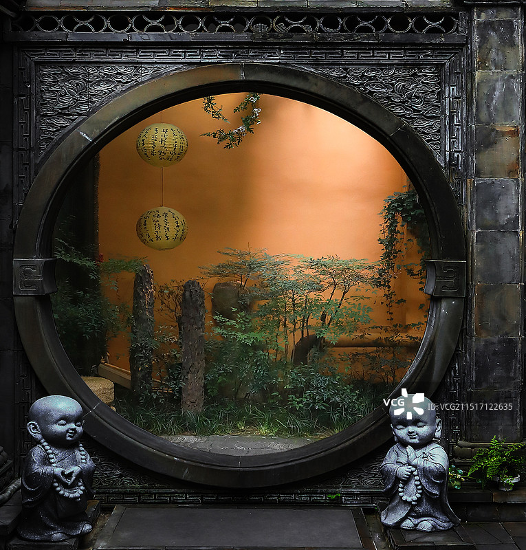 禅意拱门前站立两个石雕小沙弥图片素材