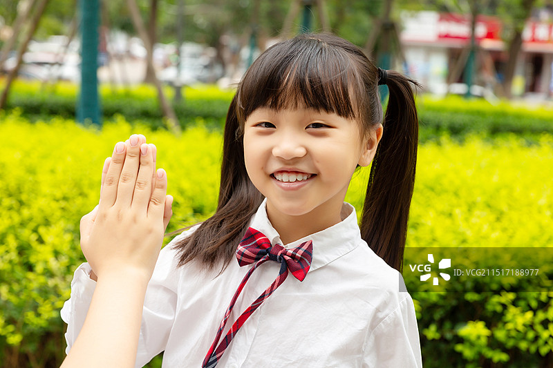 在户外击掌的亚洲小学女生图片素材