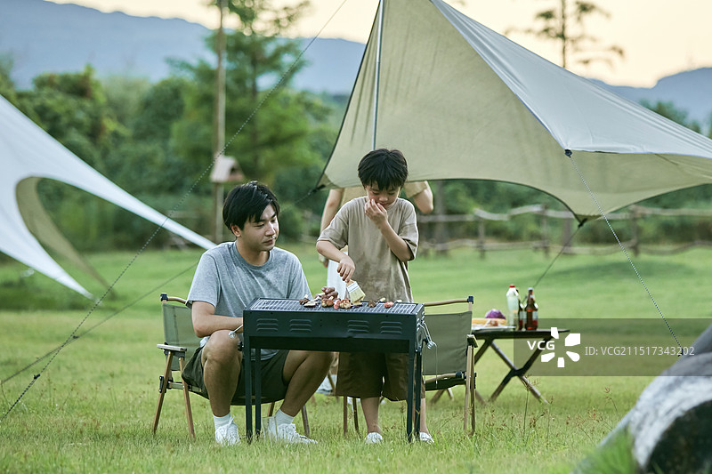 父亲教孩子们如何烧烤图片素材