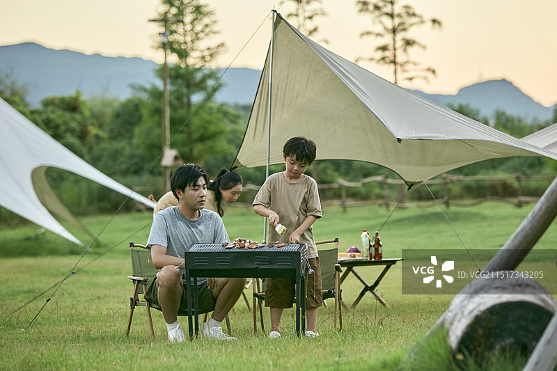 父亲教孩子们如何烧烤图片素材