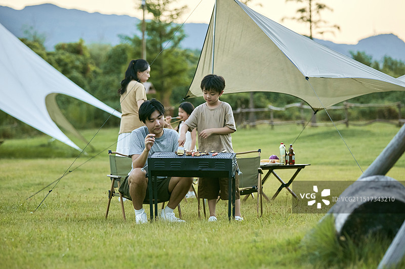 父亲教孩子们如何烧烤图片素材