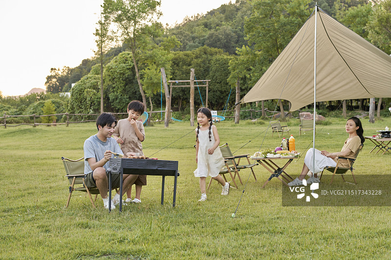 一家四口进行户外烧烤图片素材