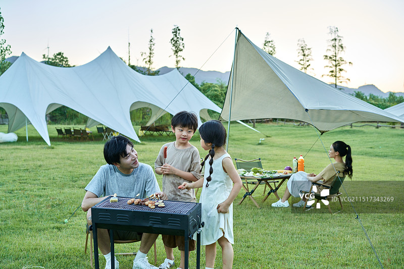 一家四口进行户外烧烤图片素材