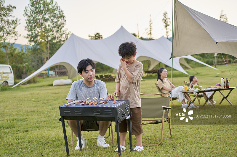 父亲教孩子们如何烧烤图片素材