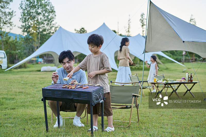 父亲教孩子们如何烧烤图片素材