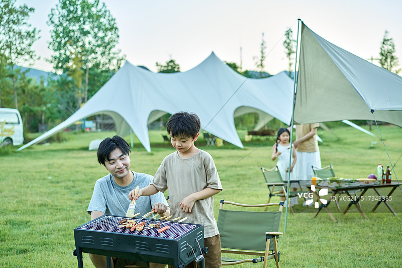 父亲教孩子们如何烧烤图片素材