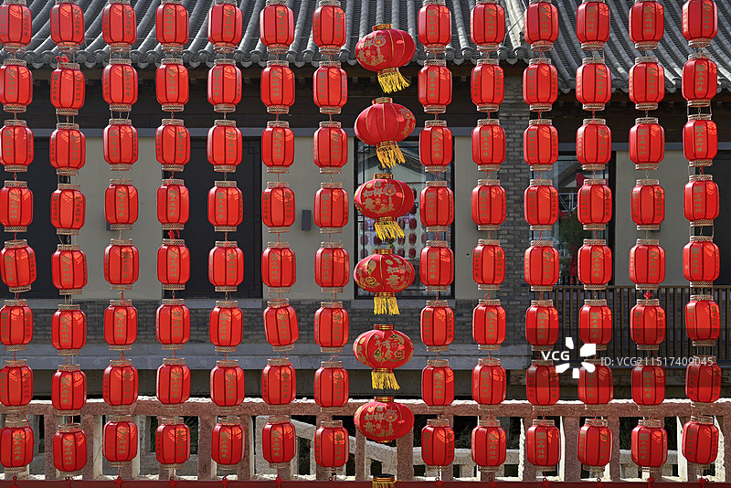 白天日光下中国内蒙古自治区巴彦淖尔“五原印巷”古典建筑前悬挂的一排排红色中国灯笼满画幅特写图片素材