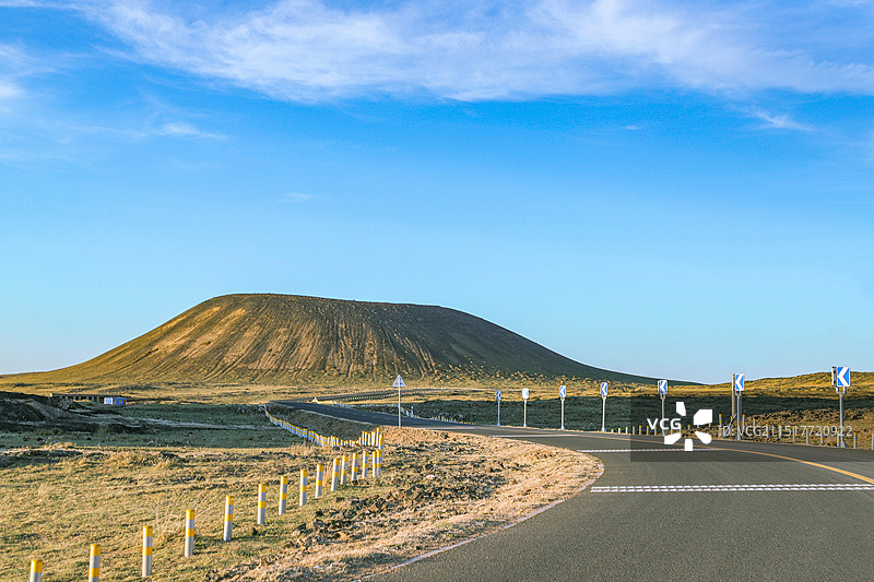 蓝天映衬下的草原火山风光图片素材