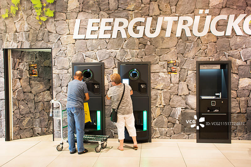 2017年8月28日，在曼海姆的超市，德国人将空瓶放入自动售货机并从机器上取钱图片素材
