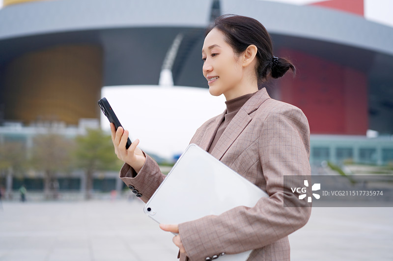 现代女商人在城市环境中进行打电话图片素材