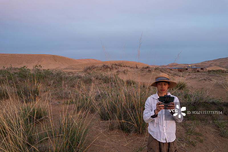 中国西部内蒙古阿拉善巴丹吉林沙漠,在使用无人机的男人图片素材
