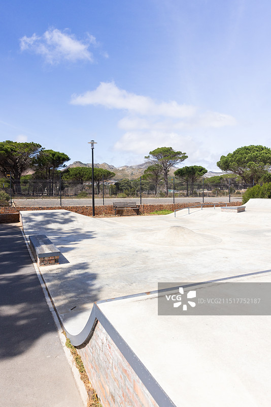 户外：空旷的滑板公园，配有长椅和树木图片素材