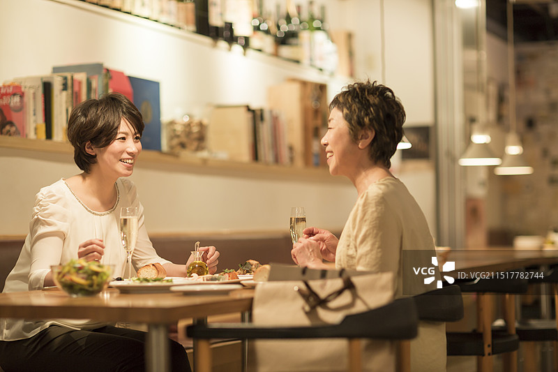 母亲和女儿在餐厅共进晚餐图片素材