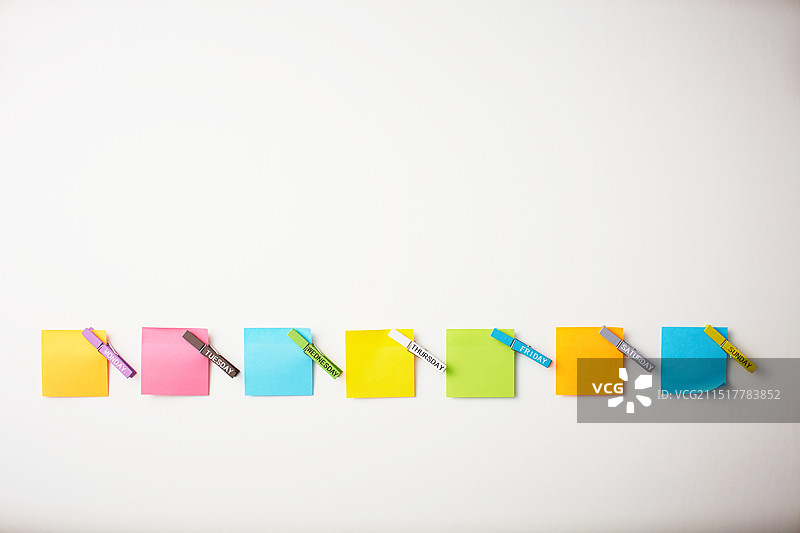 用夹子和便签固定在板上的一周日期图片素材