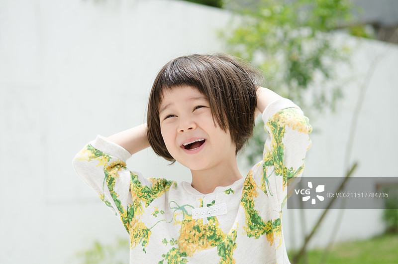 捂着头笑着的女孩图片素材