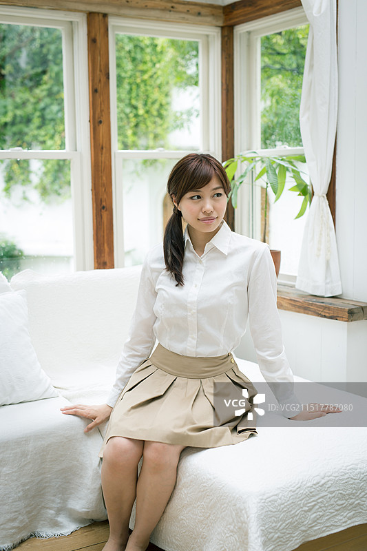 年轻女人坐在沙发上图片素材