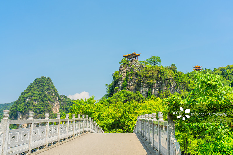 广西柳州龙潭公园石桥、中式凉亭、青山绿树与晴朗的蓝天白云风光图片素材
