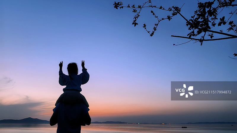日落时分红沙湾一个女孩骑在父亲肩上观赏日落图片素材