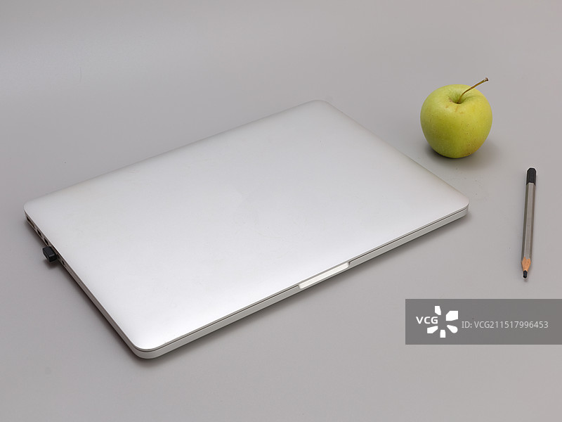 灰白色背景上的笔记本电脑和笔水果的高角度视图图片素材