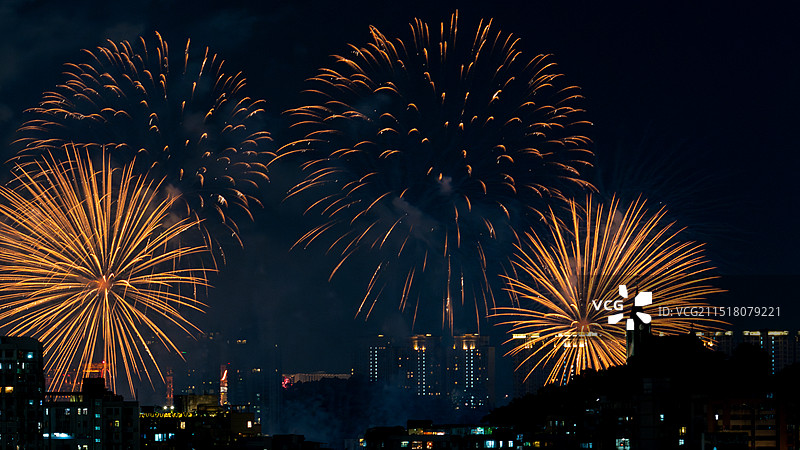 澳门烟花比赛的瞬间。橙色的烟火照亮夜空，在城市的天际线下显得格外美丽图片素材