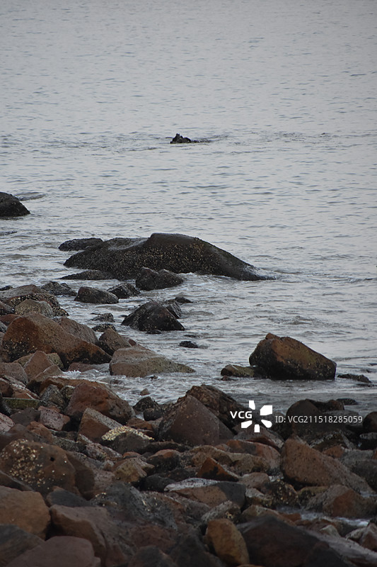 惊涛拍岸-暗沉的天空下海浪拍打黑暗的礁石图片素材