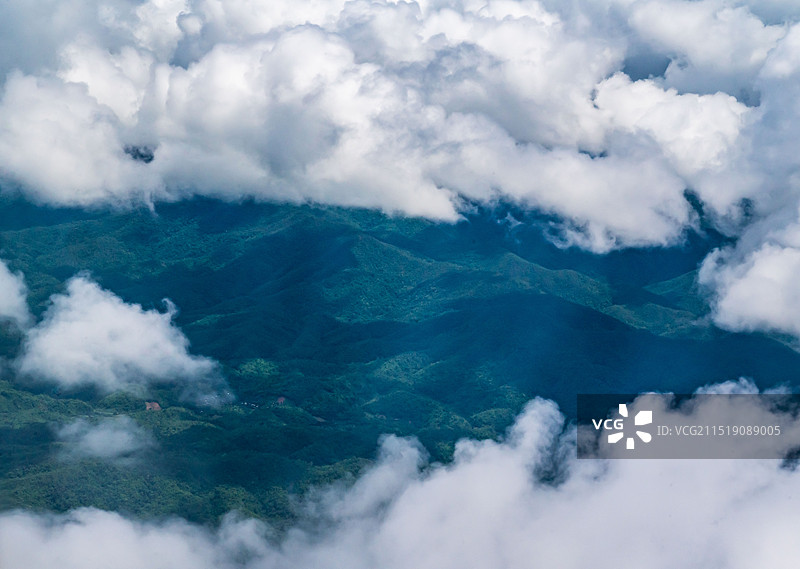 航拍洁白间露出的山峦。图片素材