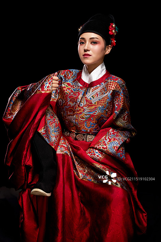 黑色背景下身着明代飞鱼服的青年女性图片素材