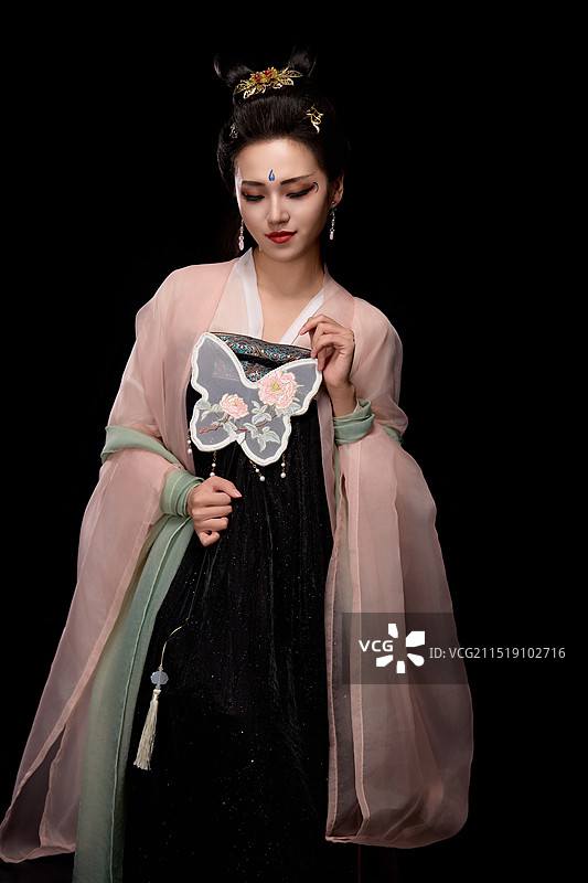 手持轻扇展示唐代服饰妆容造型的东方女性图片素材