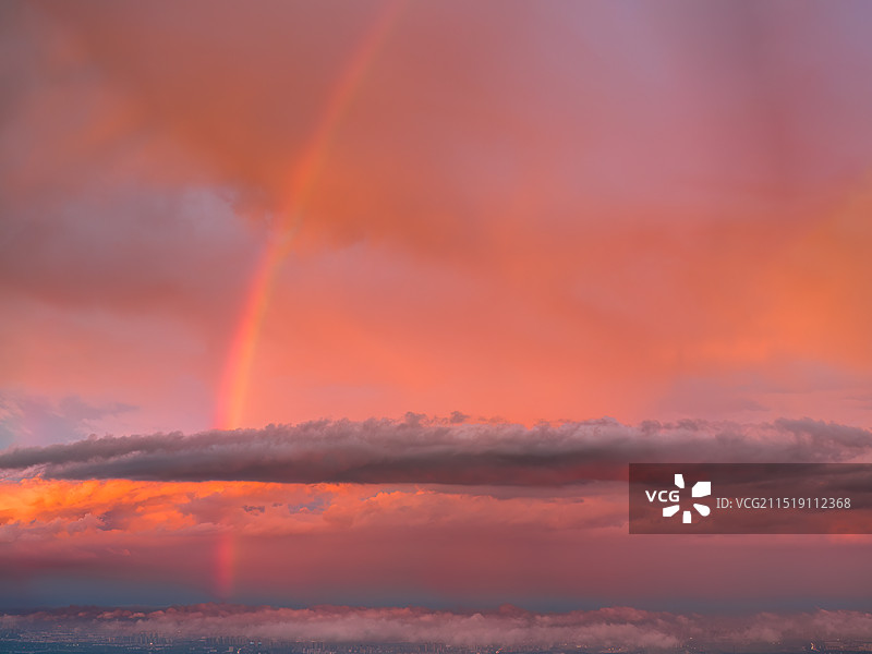 夏日雨后落日时分橙色火烧云晚霞与云层中的彩虹图片素材