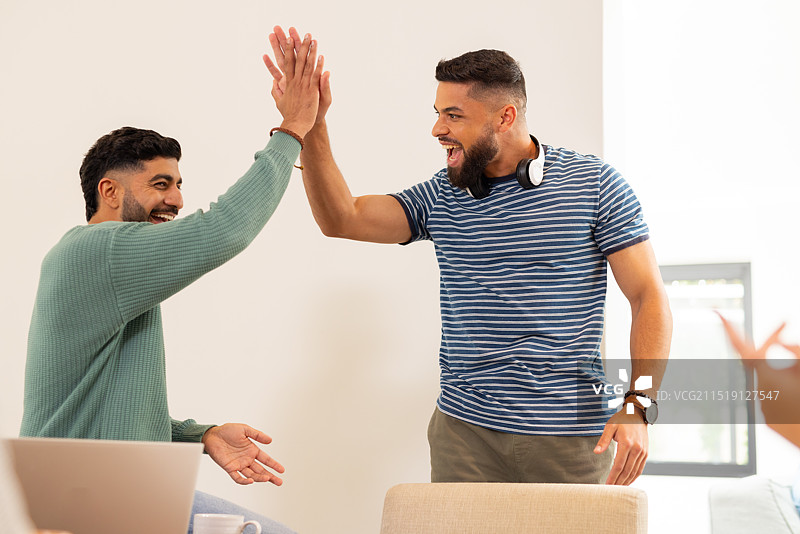 击掌庆祝，两个年轻的朋友喜悦地庆祝成功，创业图片素材
