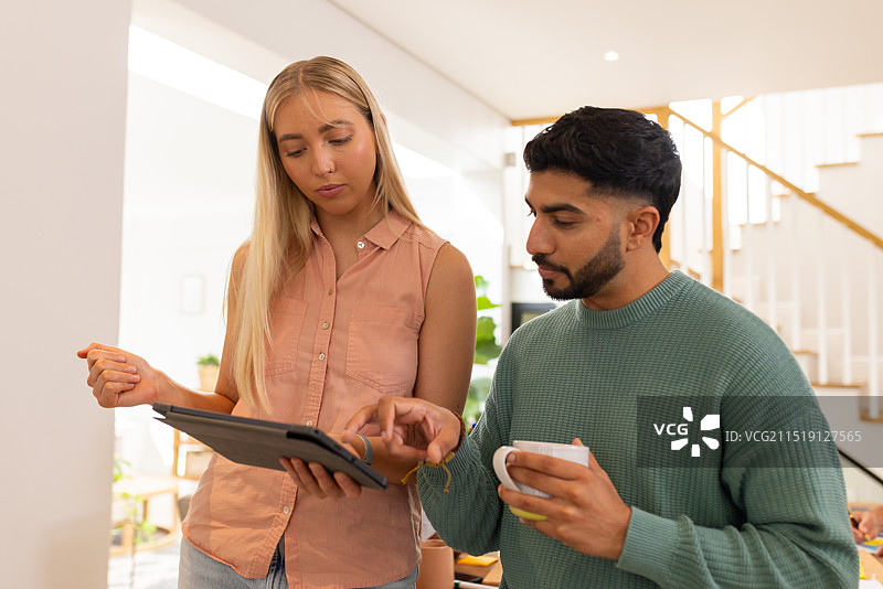 使用平板电脑喝咖啡，年轻的朋友在家讨论事情，创业图片素材