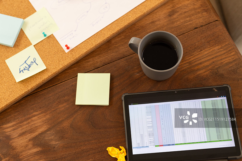 办公桌前用平板电脑和咖啡工作的人图片素材