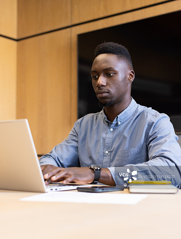 在现代办公室里专注于工作的男士图片素材