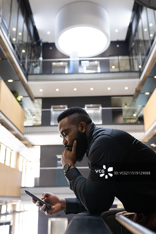 使用智能手机，非裔美国商人专注于现代办公室的工作，有复制空间图片素材