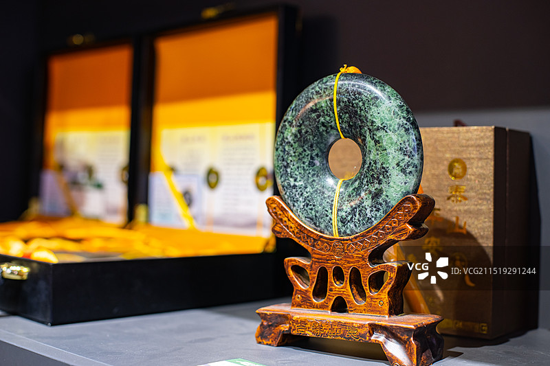 中国碧玉文化拍摄主题，木制支架上摆放着泰山墨玉雕刻的传统平安扣艺术品工艺品，室内无人图像摄影图片素材