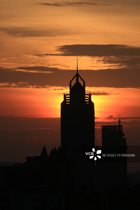 秋天日落时分橙色天空背景下的广东广州番禺中银大厦建筑剪影风光特写图片素材
