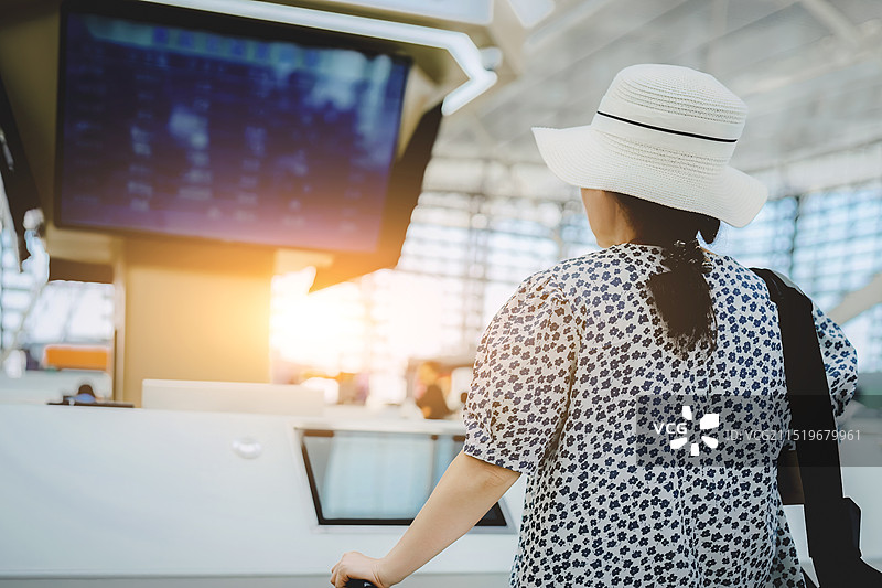 女旅客在明亮的晨光下办理登机手续图片素材
