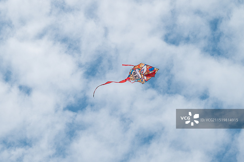 风筝在多云天空中飞行的低角度视图图片素材